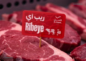 Raw ribeye steaks displayed with bilingual Al Aseel label showing price AED 40 per kilogram."