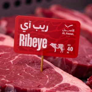 Raw ribeye steaks displayed with bilingual Al Aseel label showing price AED 40 per kilogram."