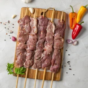 "Six skewers of raw marinated meat with chili peppers, garlic, shallots, parsley, and spices on a wooden board."